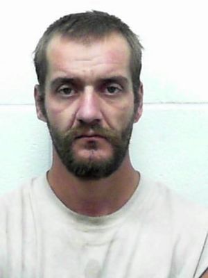 Mugshot of a man with a serious expression and short beard.